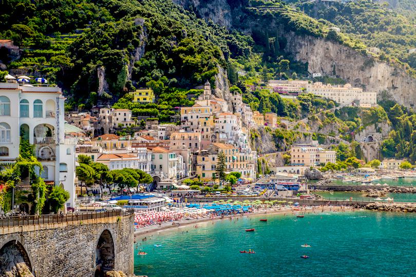 Uma visão impressionante da cidade de Amalfi, com suas casas brancas em cascata na encosta e suas águas azuis cristalinas.